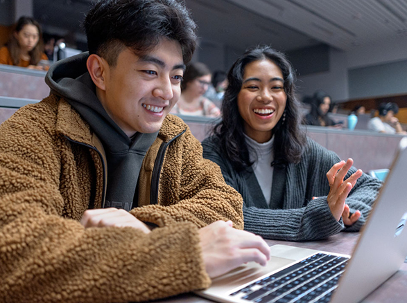 Two students working together on a laptop togethre.